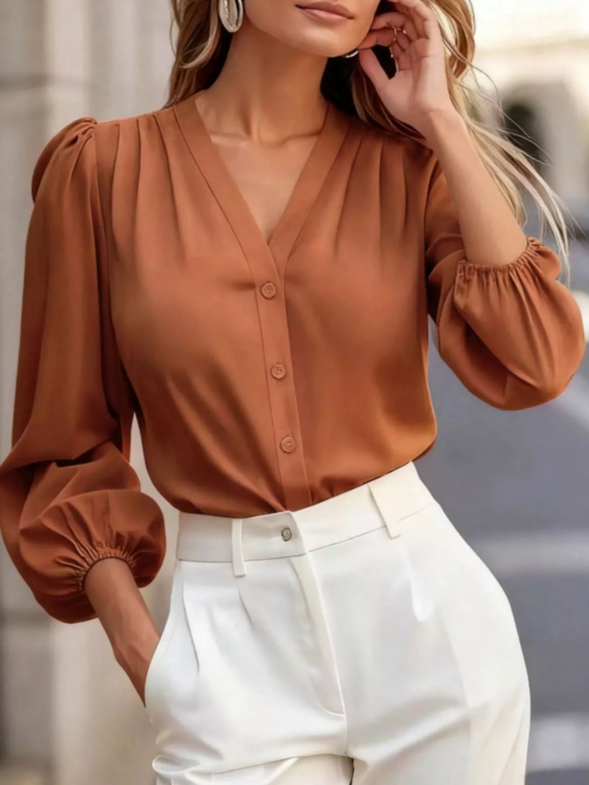 V-neck puff-sleeve button-down shirt in orange, raised-arm front view