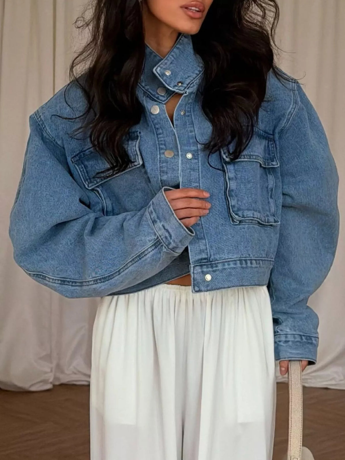 Blue oversized cropped denim utility jacket, front view showing flap pockets.