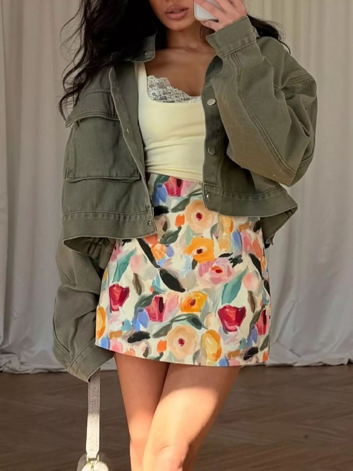 Olive oversized cropped denim utility jacket, front view with raised sleeve.