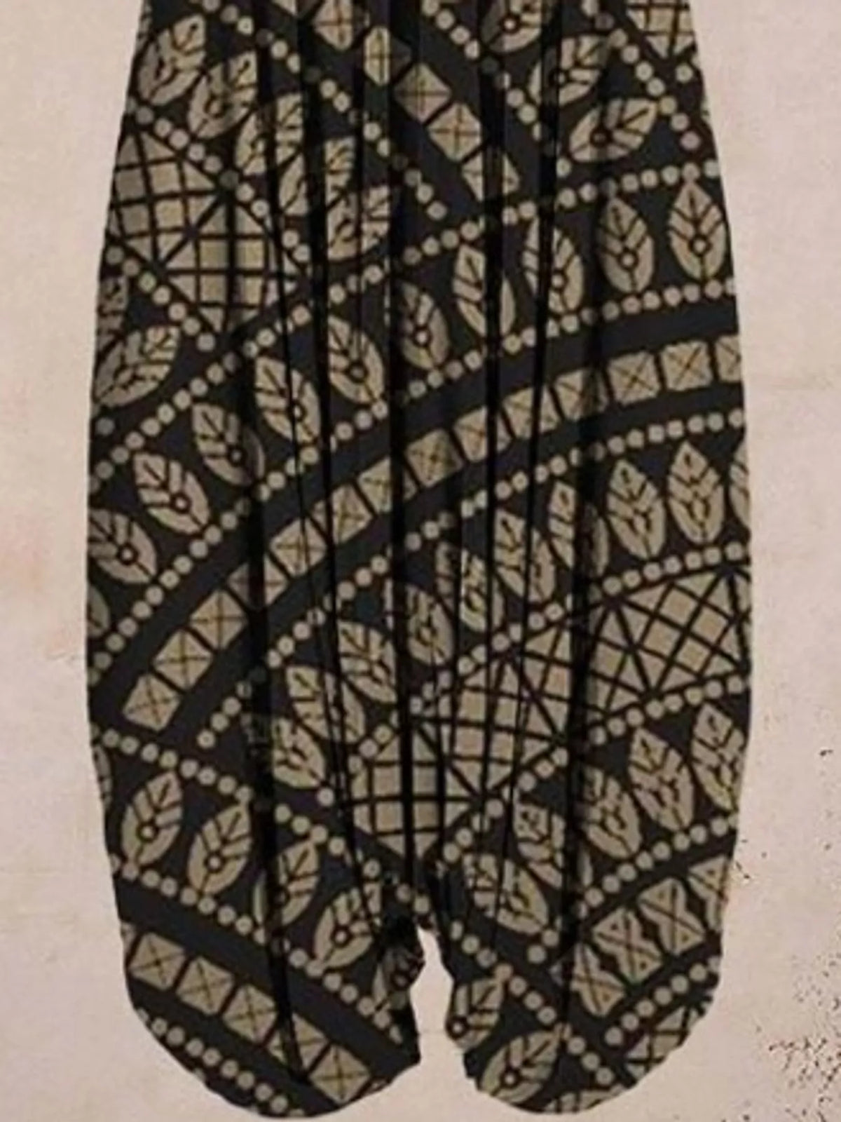 Black geometric-print V-neck sleeveless jumpsuit, leg and print detail