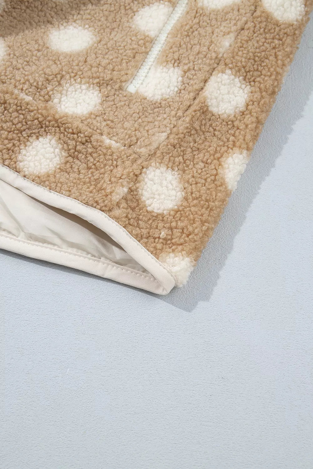 Tan and white polka dot faux fur button-front jacket with zip pockets, hem and lining detail