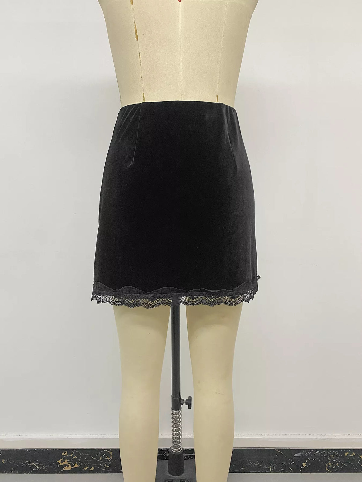 Black velvet mini skirt with lace trim, back on mannequin