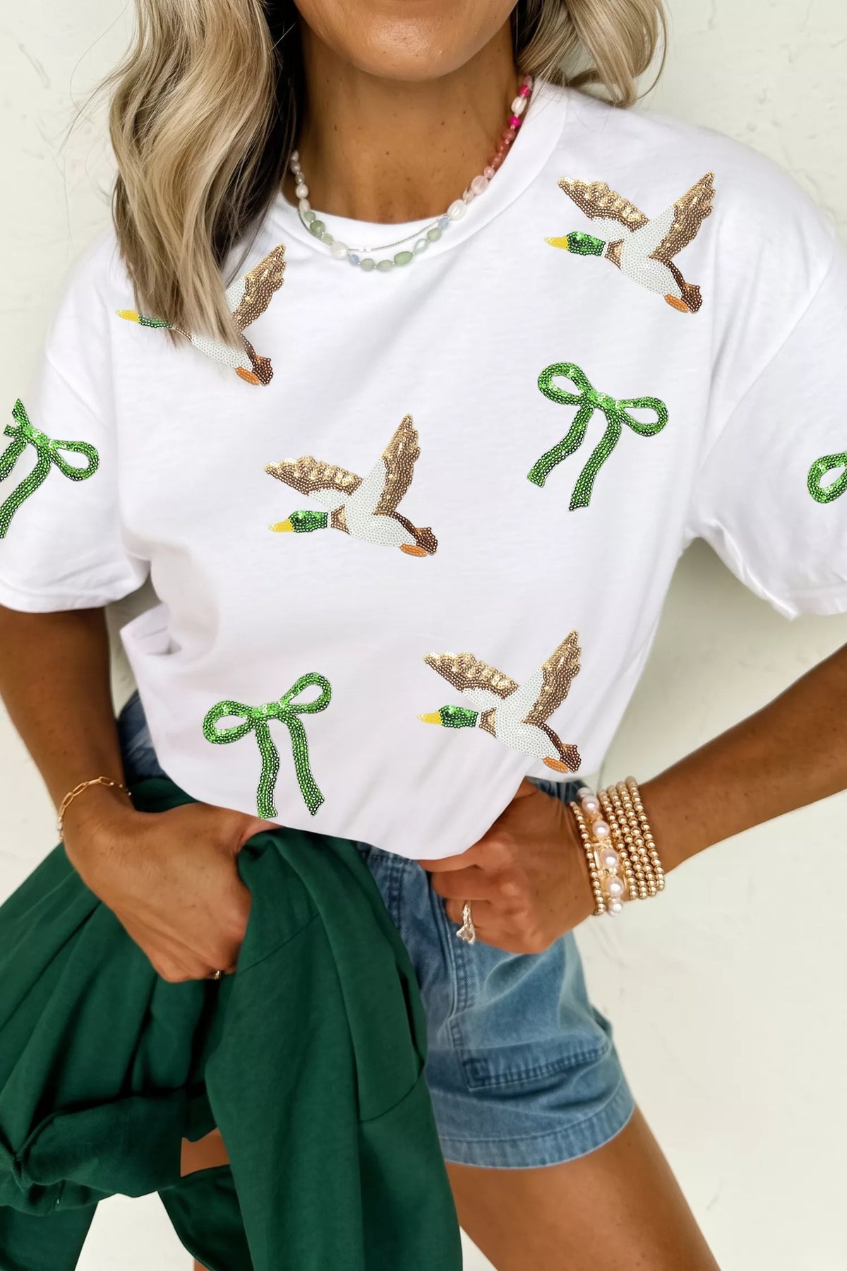 White sequin mallard and bow graphic t-shirt, front view with mallard and green bow graphics.