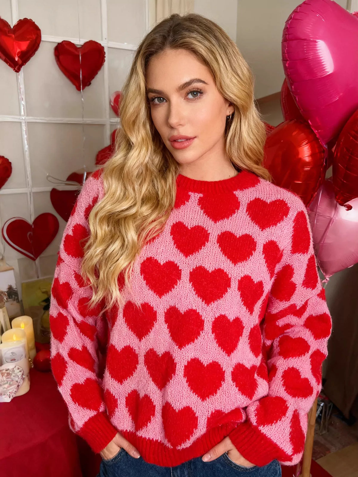 Pink and red allover heart dropped-shoulder sweater, front view.
