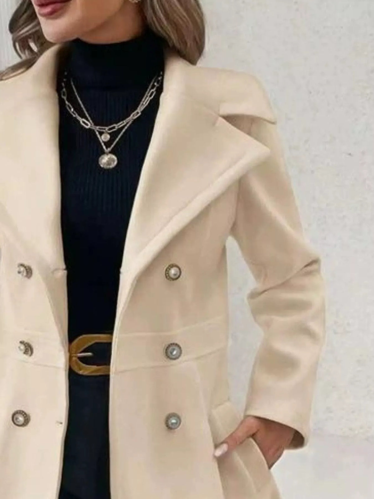 Beige double-breasted peplum coat, lapel and button close-up