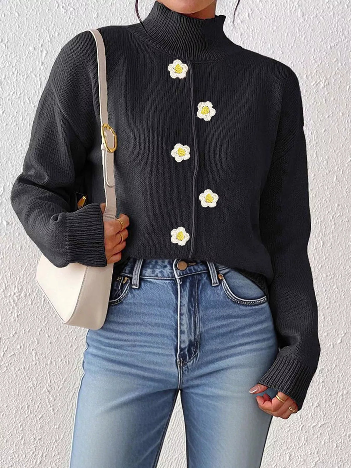 Black floral applique mock-neck sweater, front partially tucked.