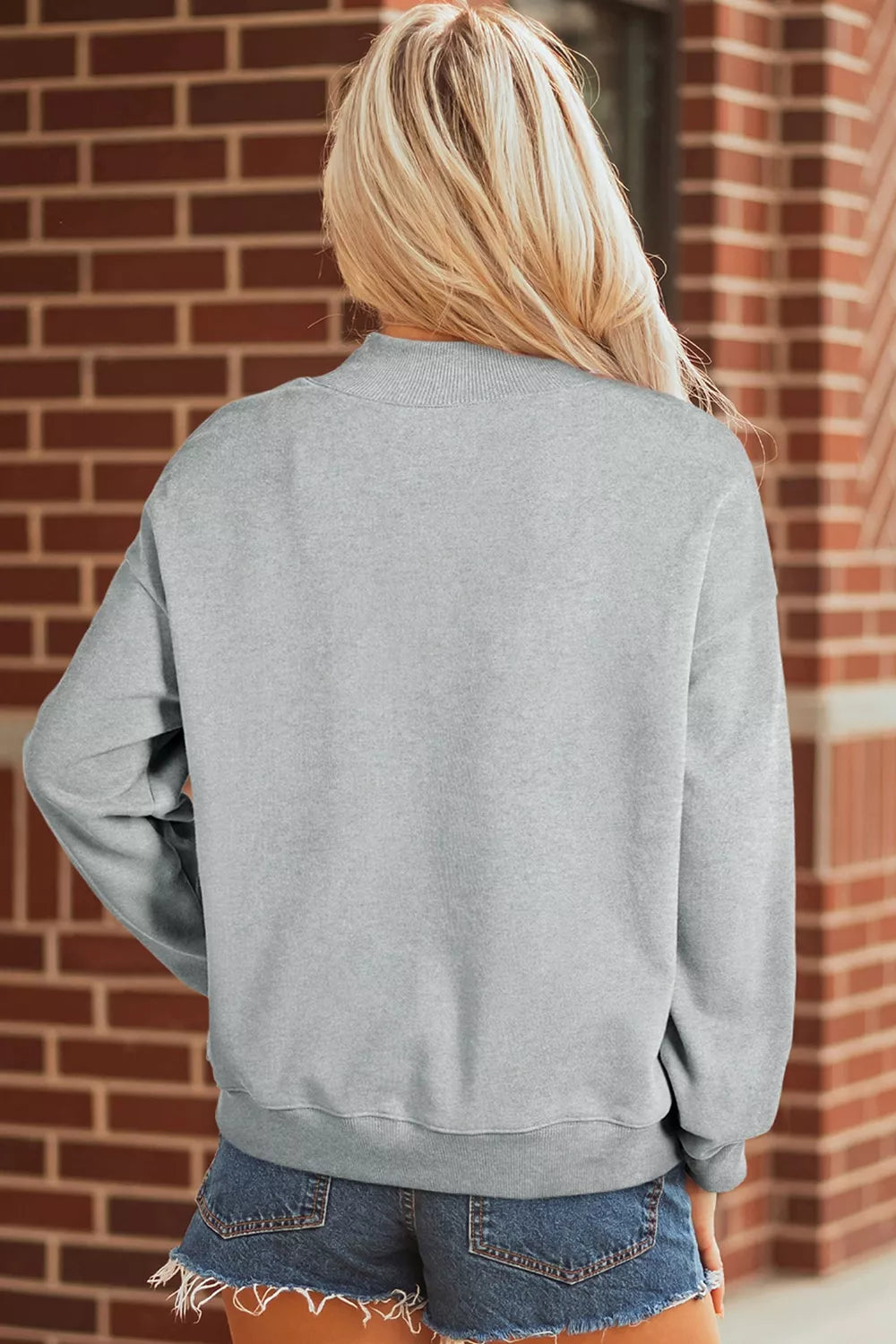 Gray lucky mallard graphic mock-neck sweatshirt, back view with denim shorts.