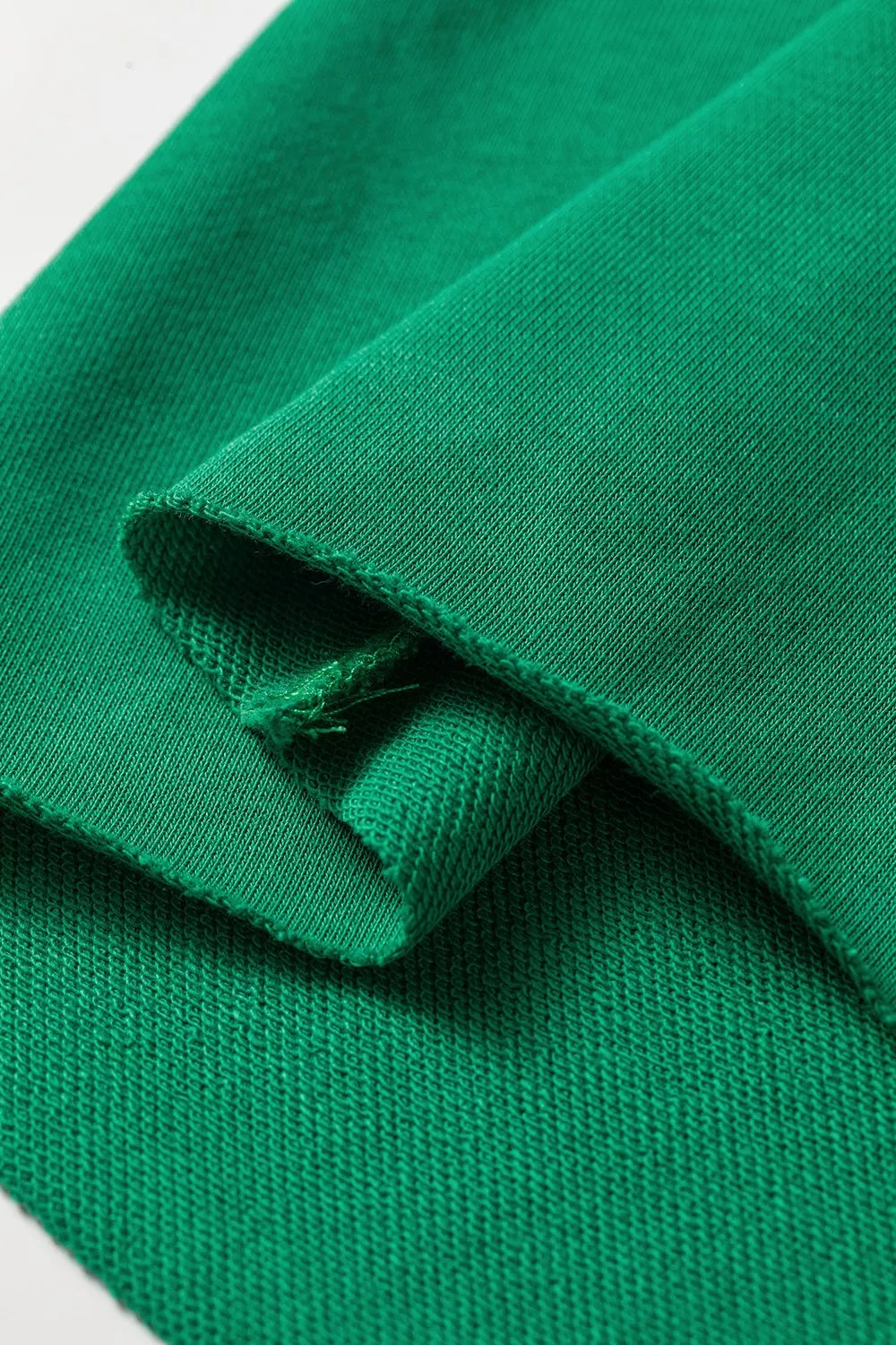 Green hooded top and wide-leg pants set, fabric edge close-up