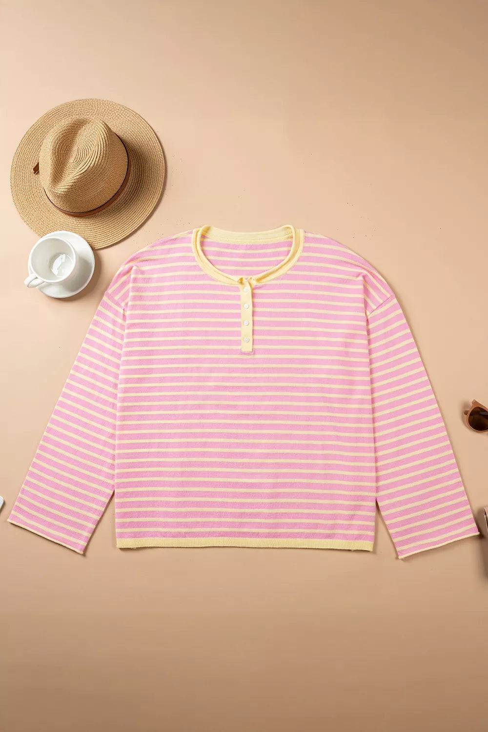 Pink and yellow striped button-detail sweater, front laid flat