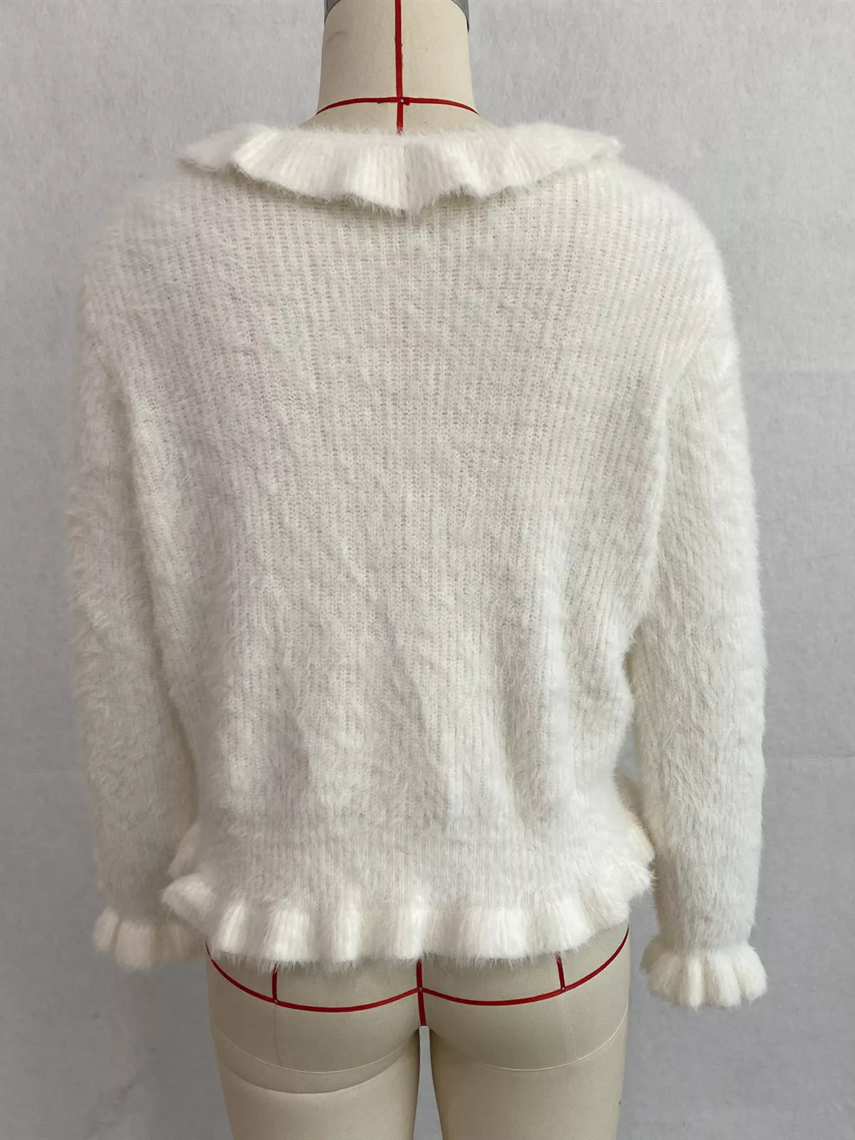 Ivory fuzzy ruffle-trim button-front cardigan, back on dress form.