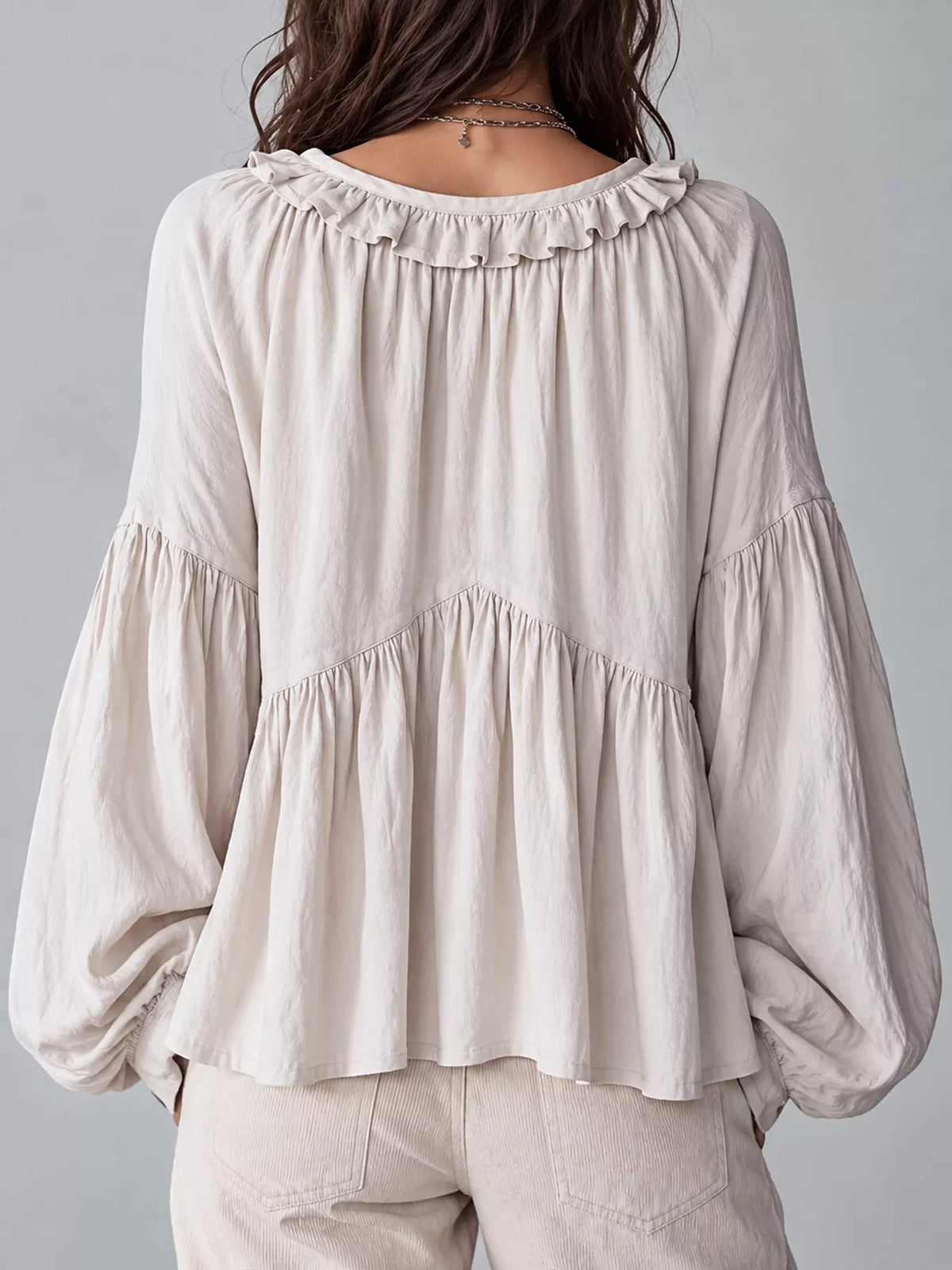 Cream ruffled v neck blouse, back view
