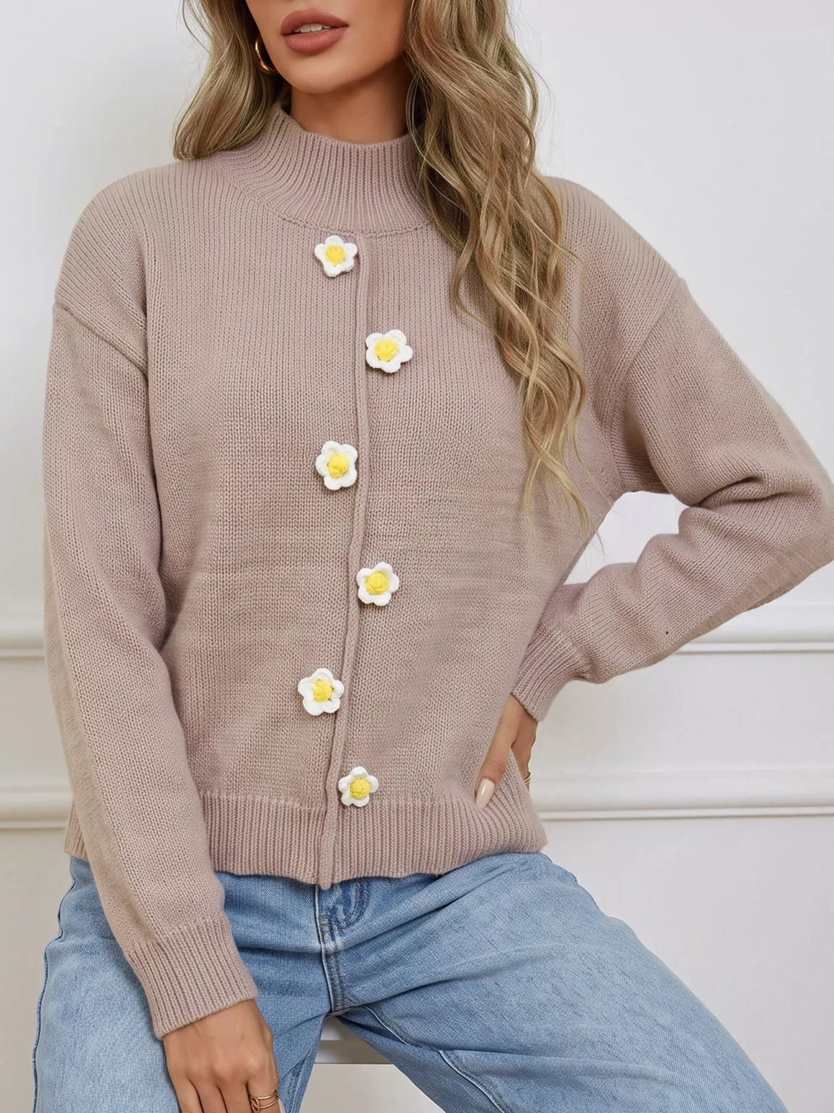 Taupe floral applique mock-neck sweater, front with hand at waist.