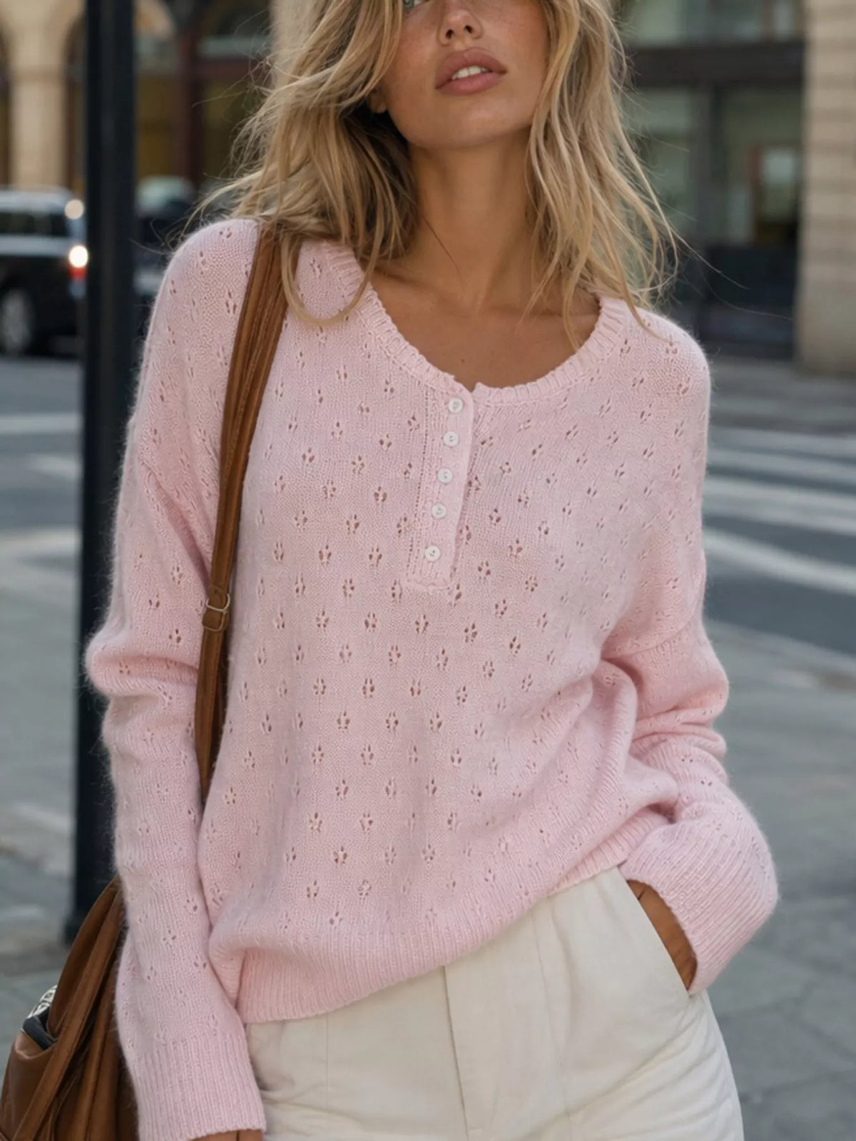 Pink pointelle round-neck knit top, front detail.