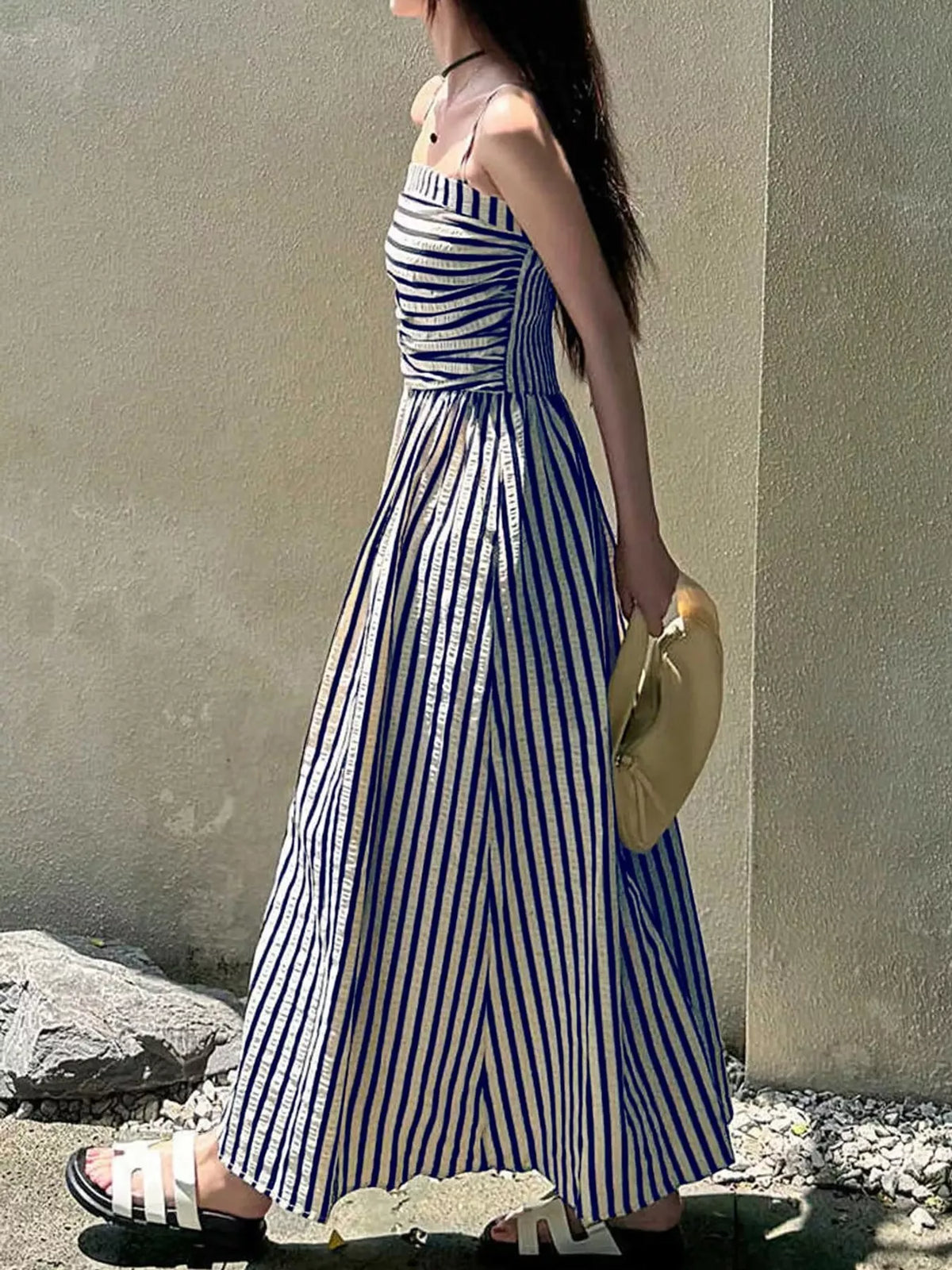 Navy and white striped spaghetti strap maxi dress with gathered bodice and pockets, side view