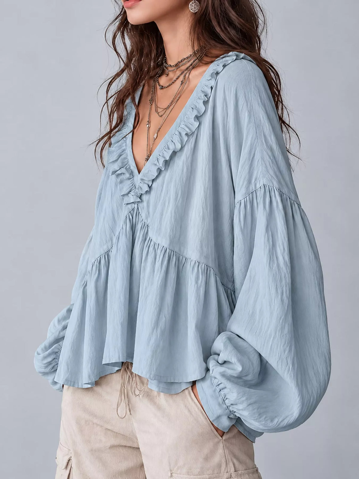 Light blue ruffled v neck blouse, side view