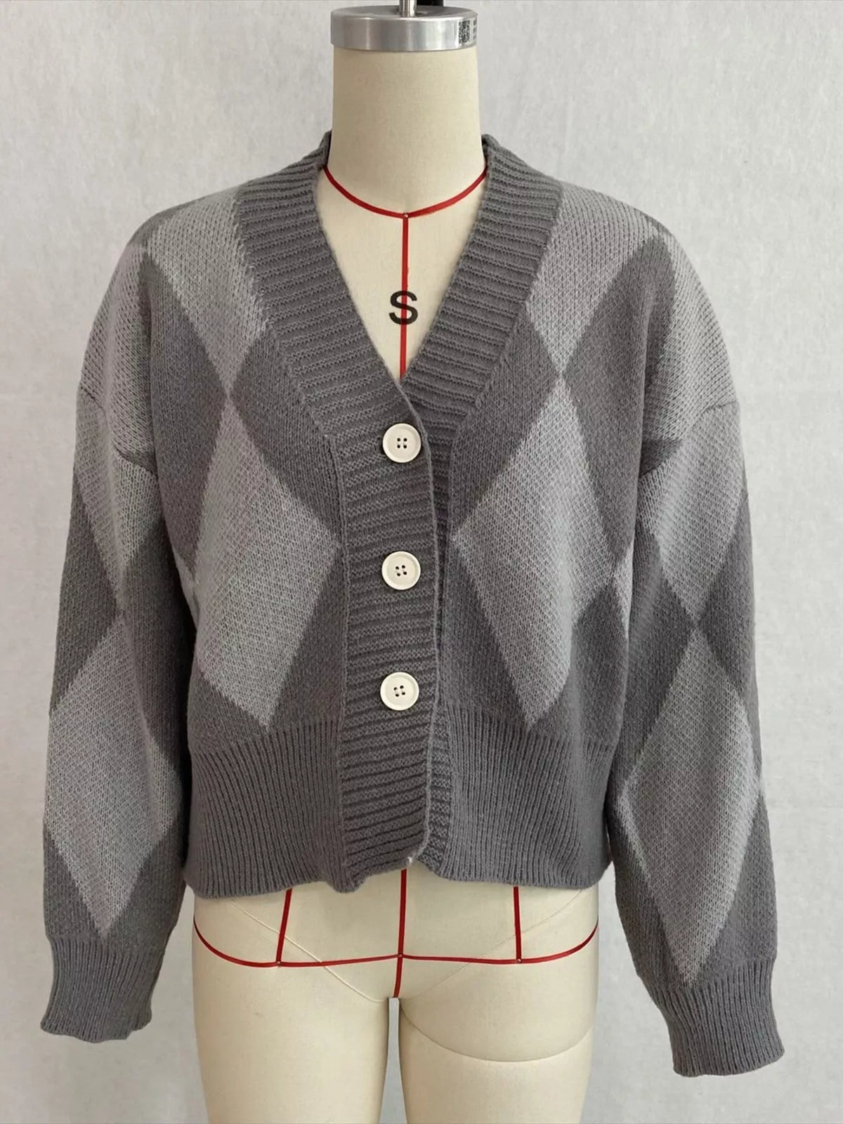 Gray argyle v-neck button-front cardigan, front on dress form.