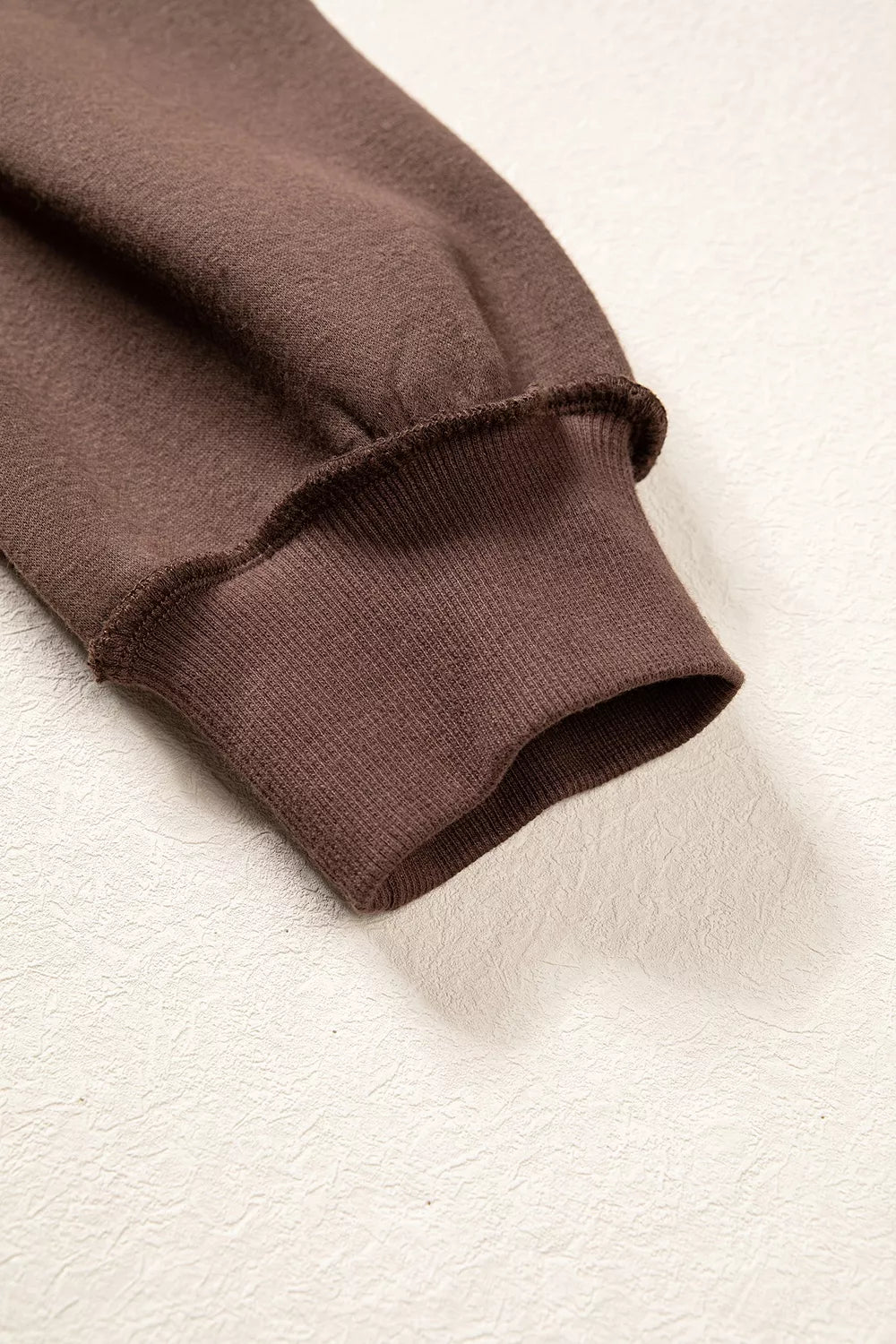 Brown wwjd patchwork graphic mock-neck sweatshirt, cuff detail.