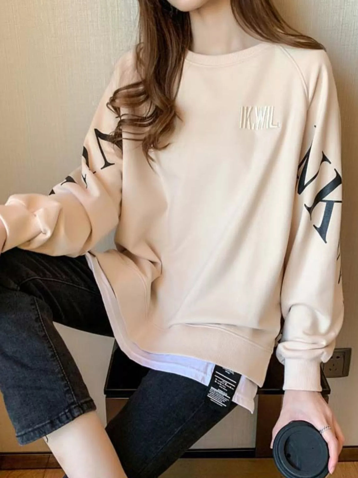 Apricot layered-hem sweatshirt with graphic sleeve detail, back view