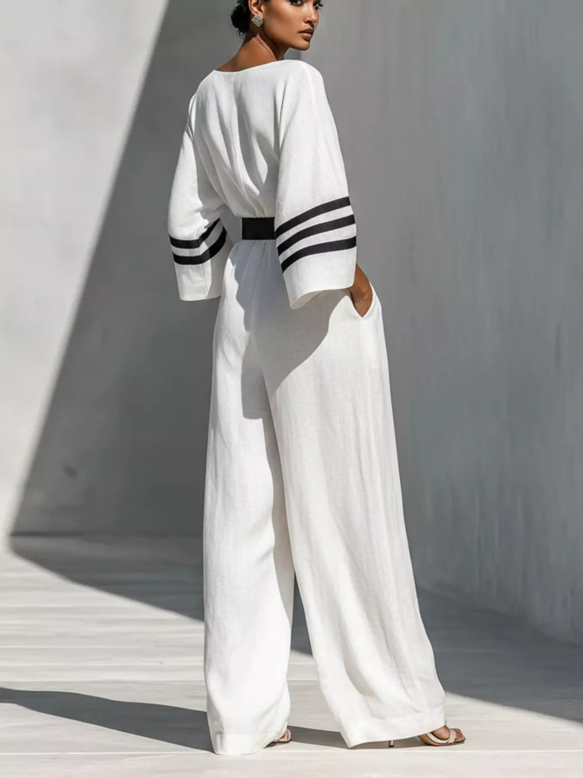 White wide-sleeve jumpsuit with striped trim, back view.