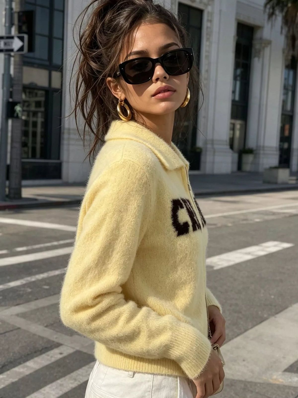 Yellow fuzzy letter zip-up cardigan, side view.