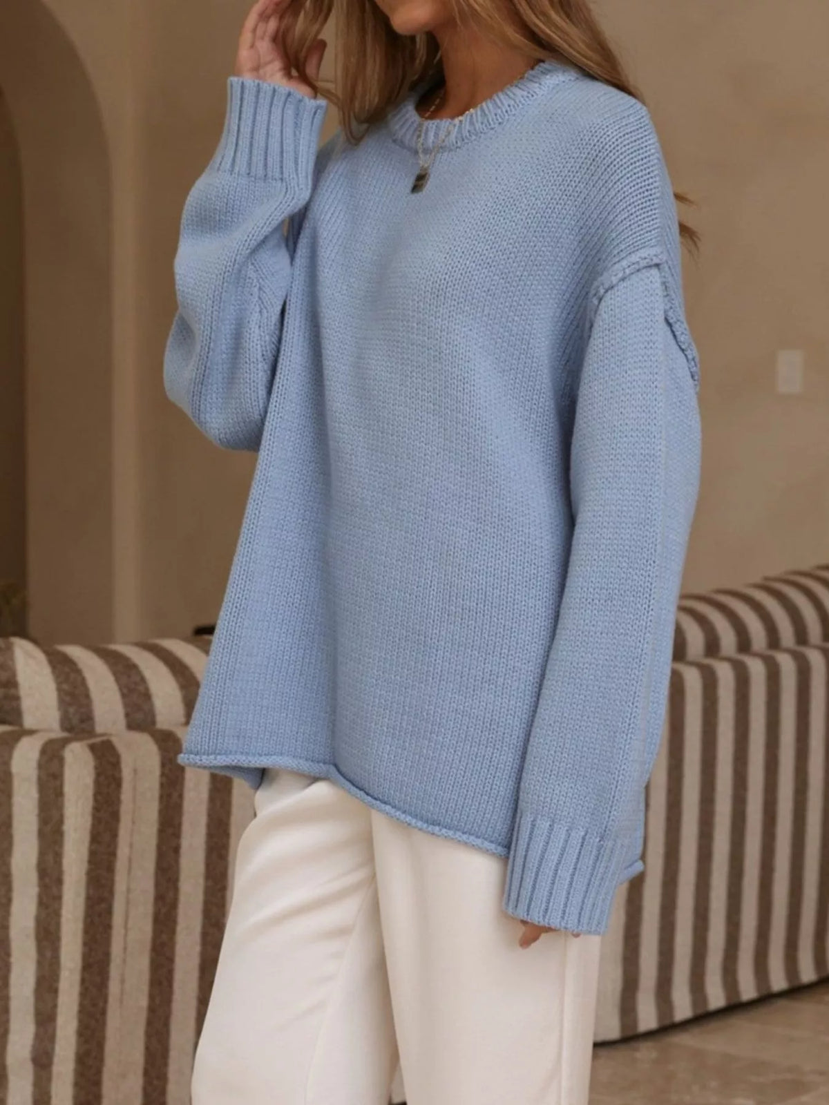 Light blue crewneck dropped-shoulder sweater, angled front view.