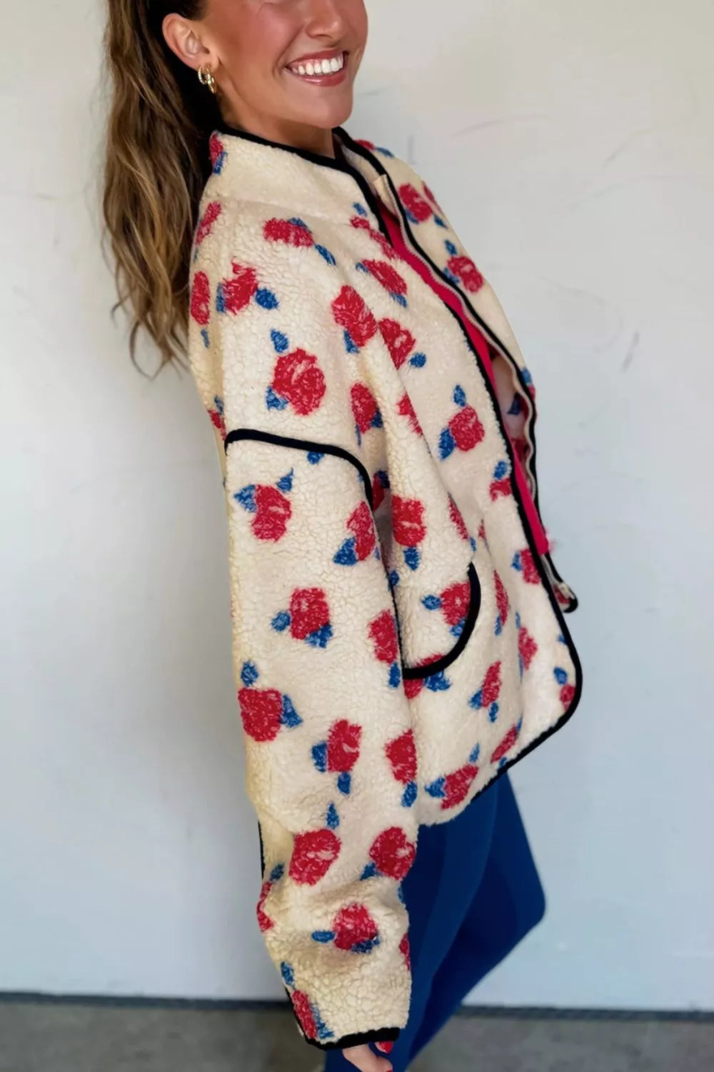 Cream with red flowers floral zip-up fleece jacket, side view showing pocket.