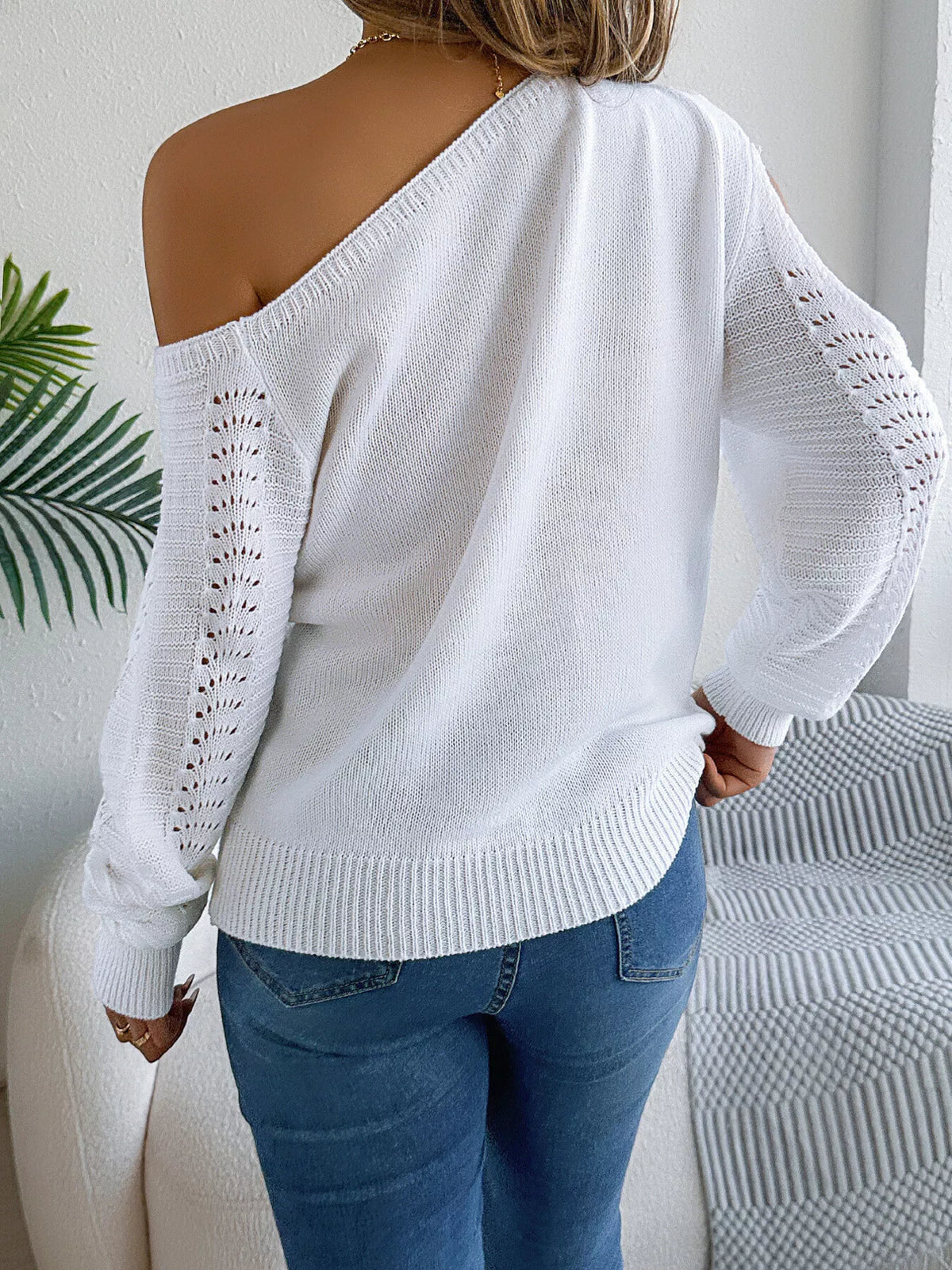 White cold-shoulder openwork knit sweater, back view.