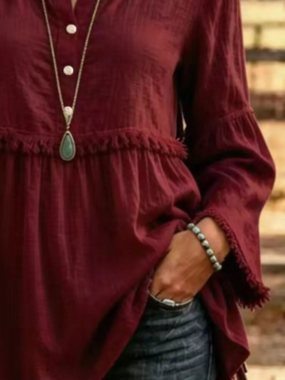 Burgundy fringed button detail blouse, button front, waist seam, and sleeve