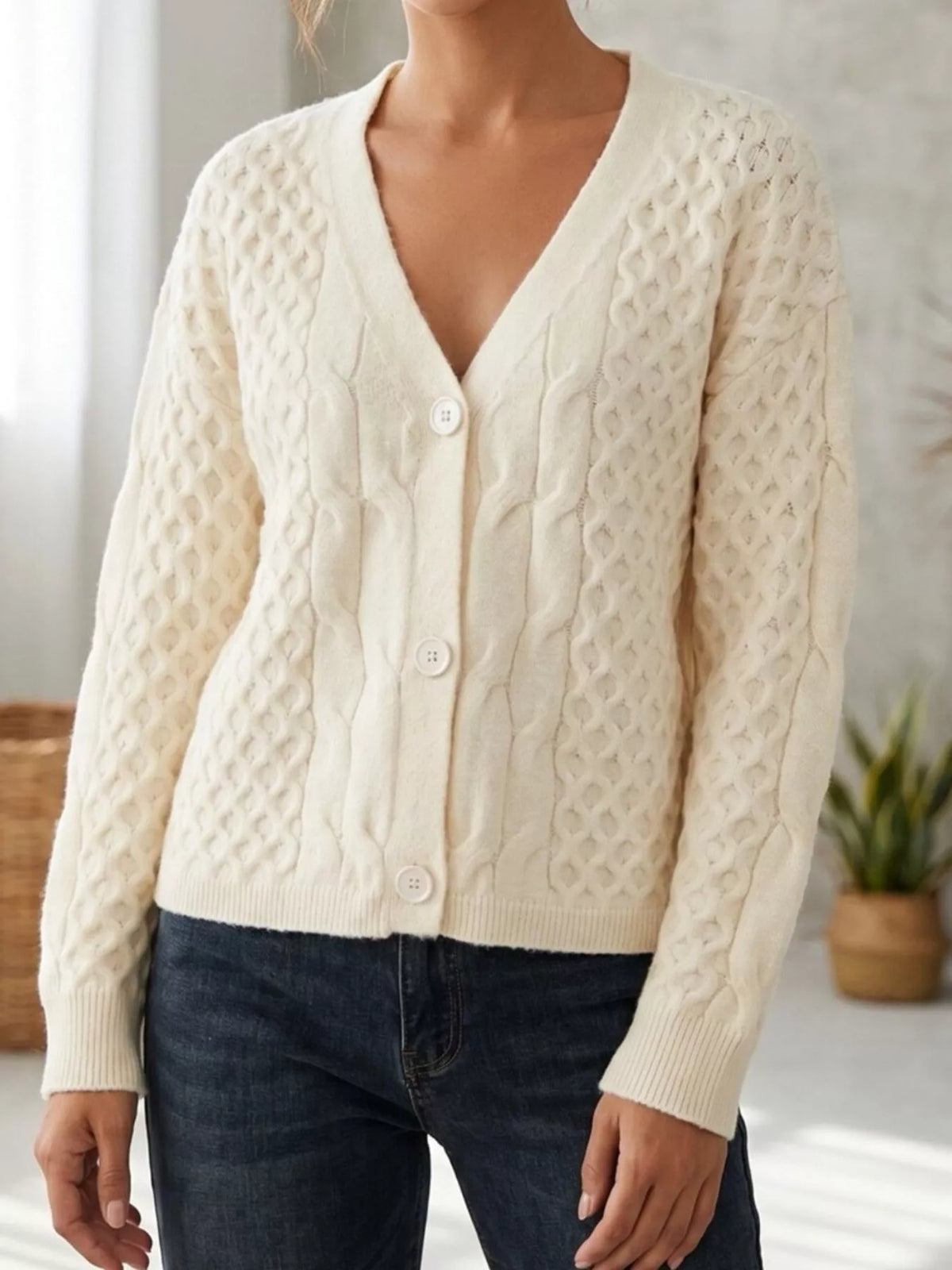 Ivory cable-knit v-neck button-front cardigan, angled front view.