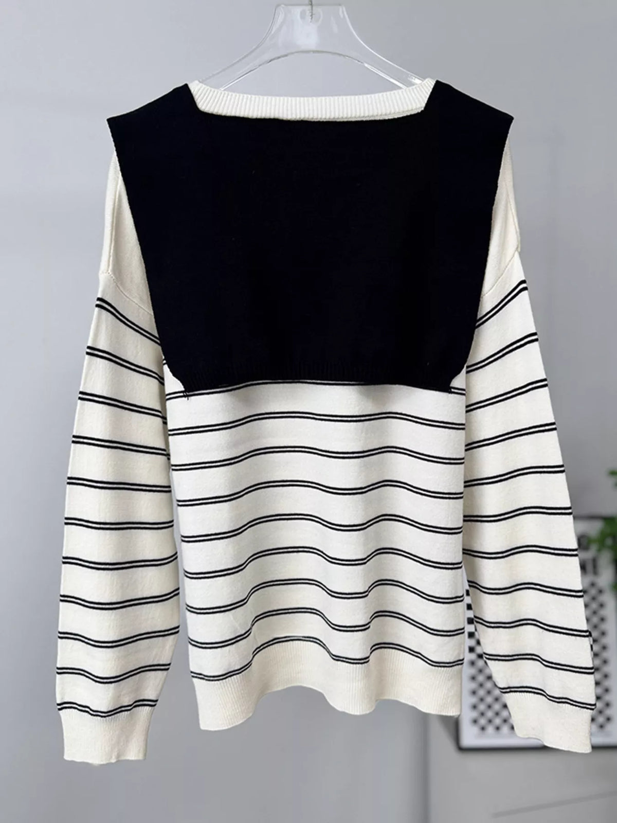 Striped crewneck sweater with layered tie detail in white and black, hanging back view with layer