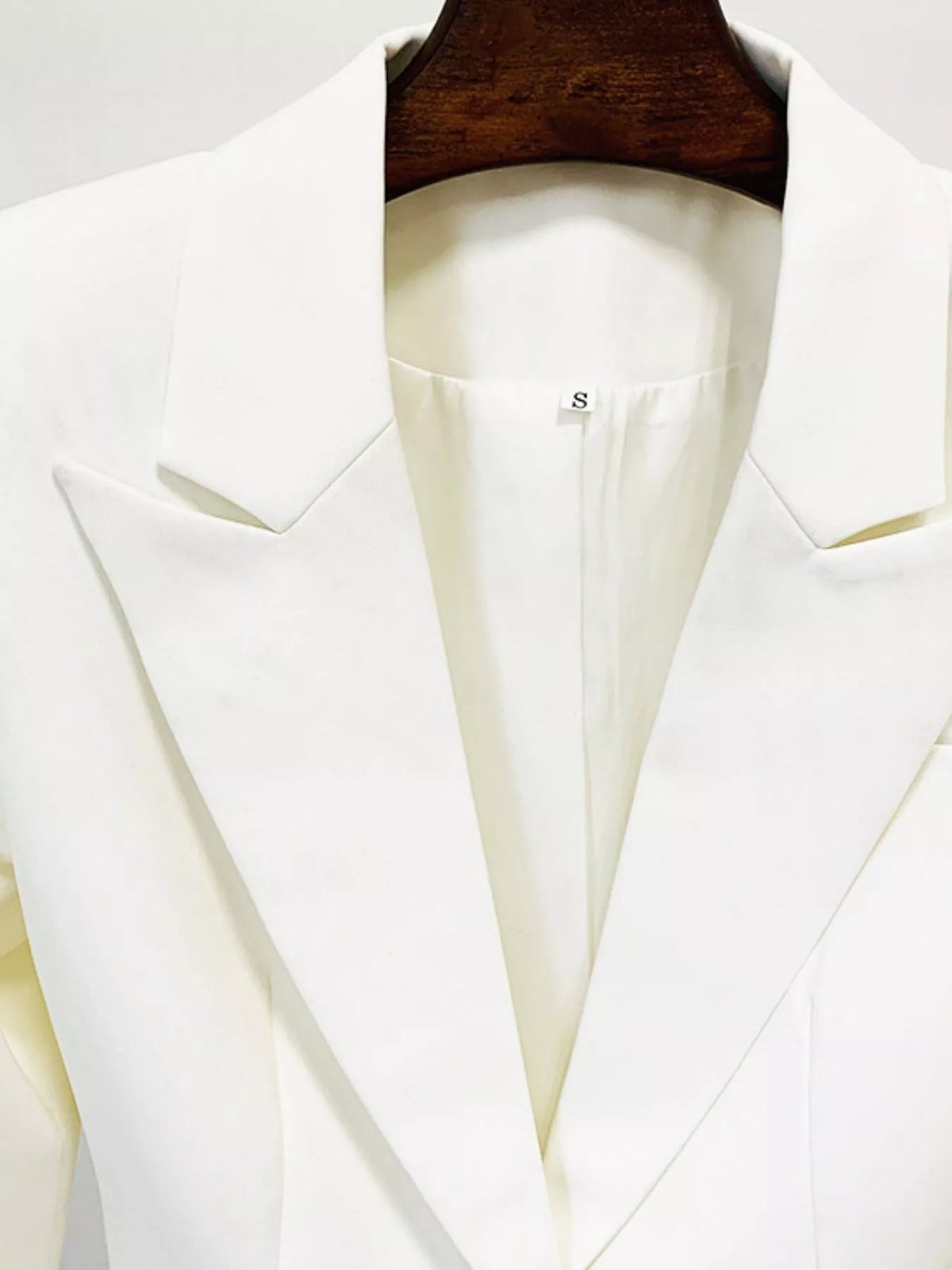 White one-button blazer and flared pants set, detail view