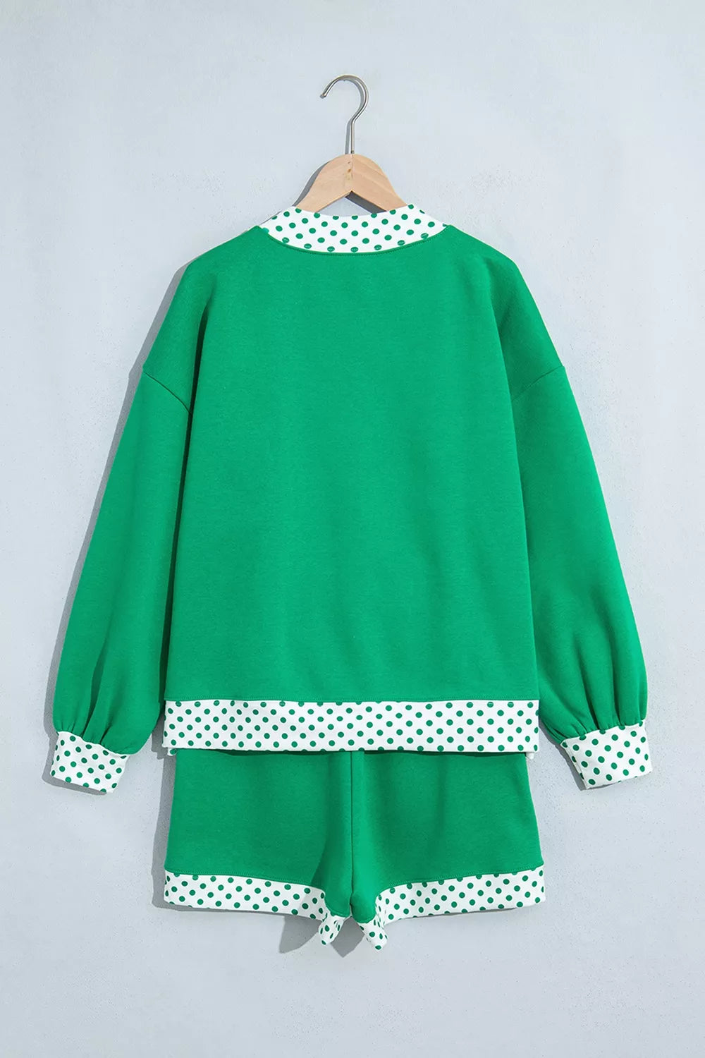 Green sweatshirt and shorts set with polka-dot trim, back on hangers
