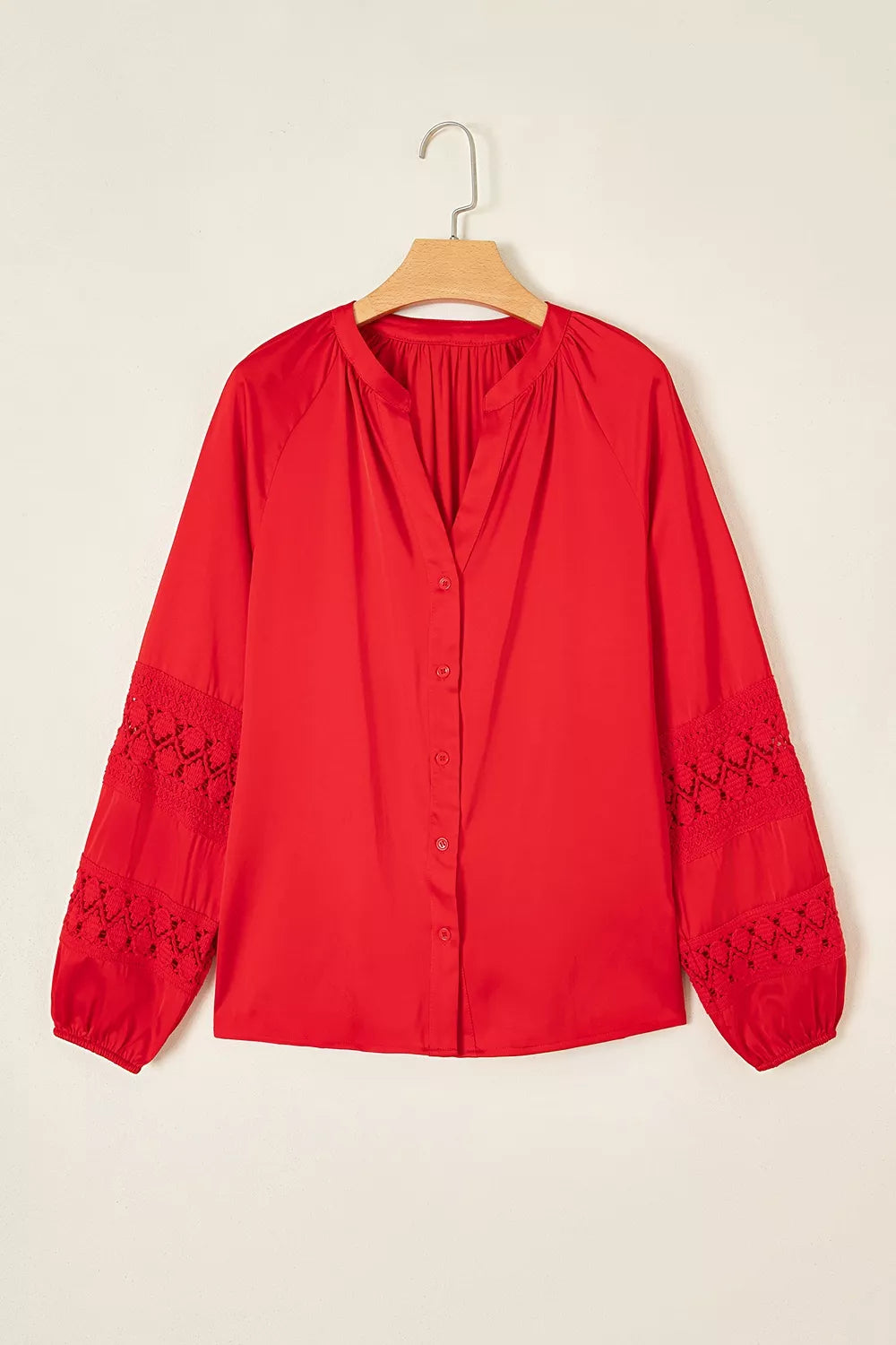 Red lace-panel v-neck button-front shirt, front on hanger.