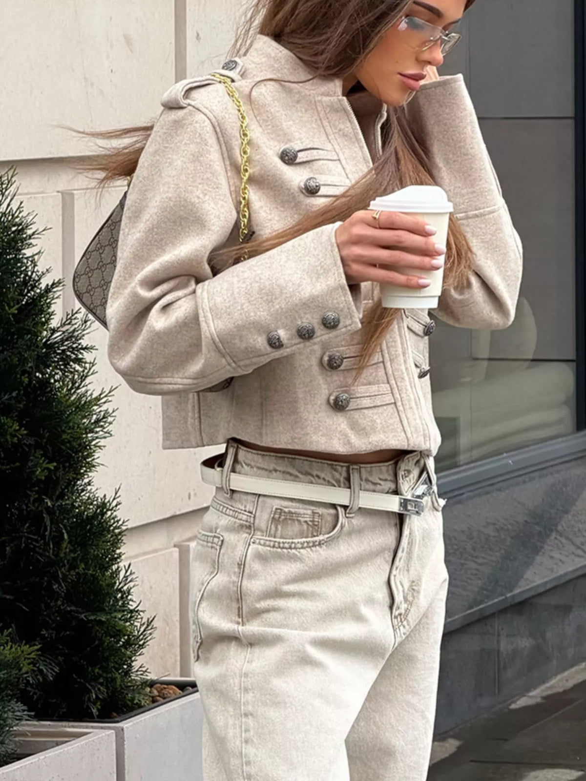 Beige cropped zip-front jacket, side view with cup