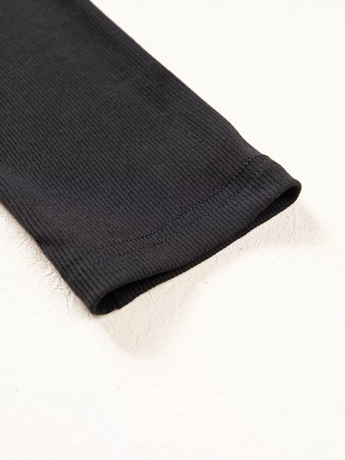 Ribbed sleeve cuff on black round neck frill detail long sleeve top