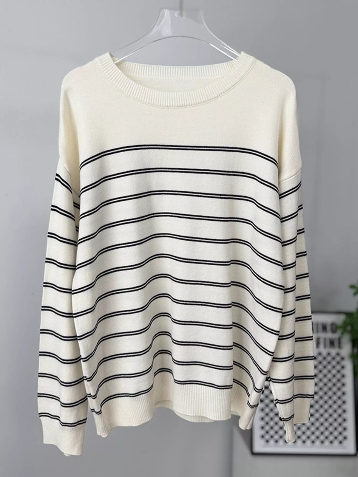 Striped crewneck sweater with layered tie detail in white and black, hanging front without layer