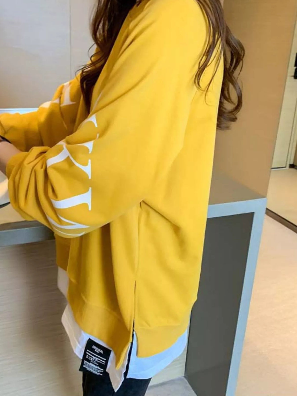 Yellow layered-hem sweatshirt with graphic sleeve detail