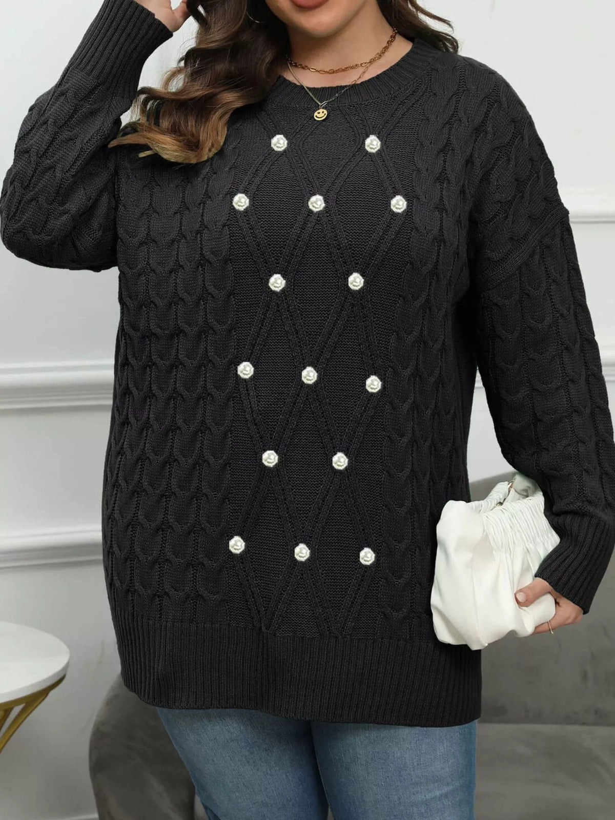 Black plus-size cable-knit sweater with pearl-like front accents, front view