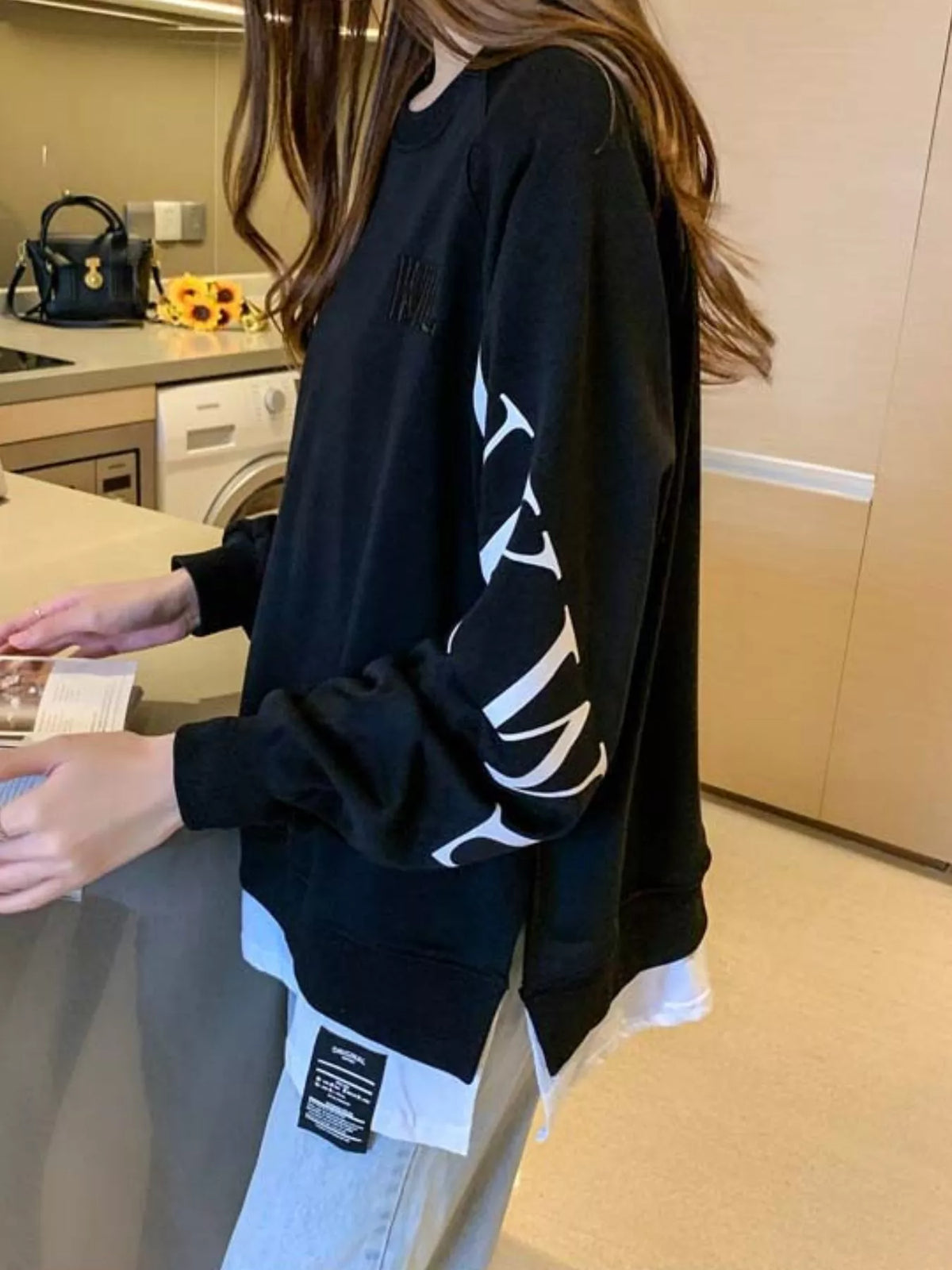 Black layered-hem sweatshirt with graphic sleeve detail
