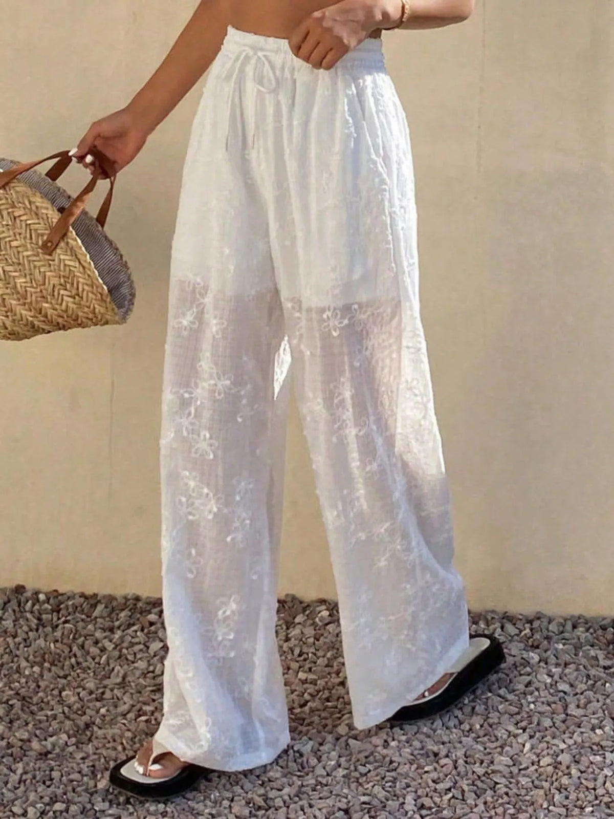 White sheer floral embroidered wide-leg pants, angled front view