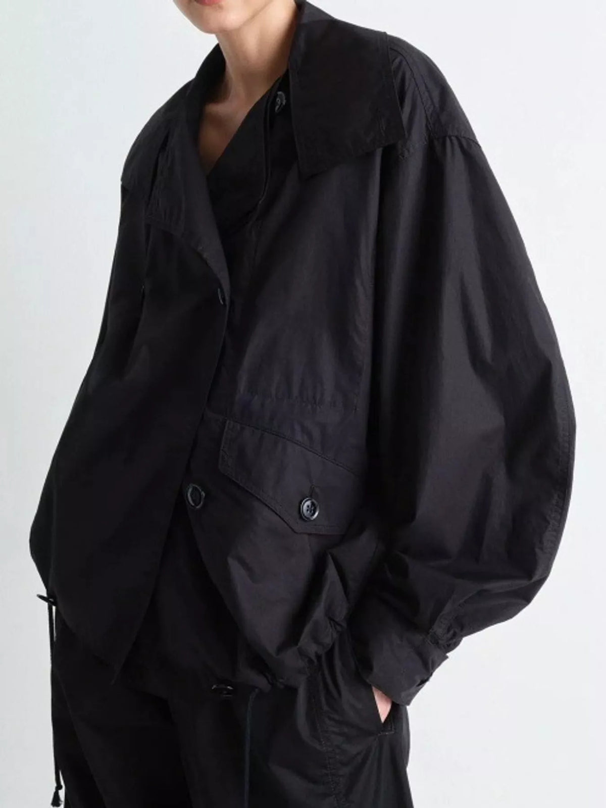 Black double-breasted utility jacket with drawstring hem — front view