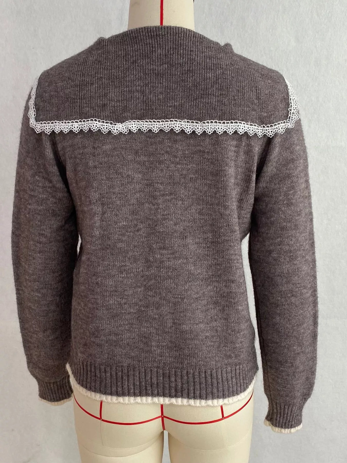 Charcoal cable-knit cardigan with lace trim, back on dress form.