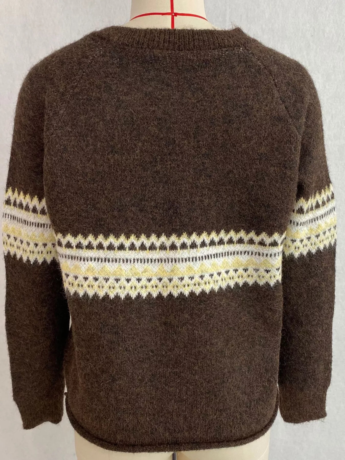Brown geometric button-front knit cardigan, back on dress form.