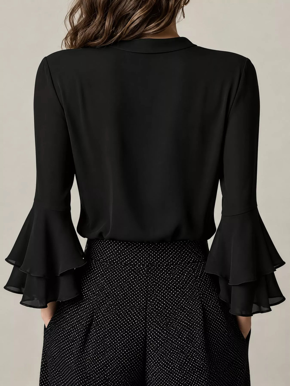 Black ruffle-trim V-neck blouse with tiered bell sleeves, back view