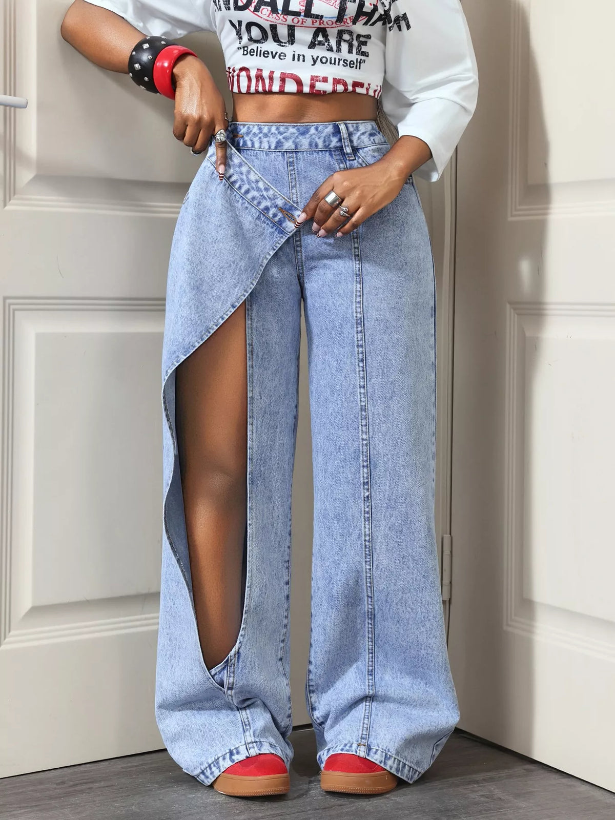 Light blue asymmetric-wrap wide-leg jeans, wrap panel and leg opening detail