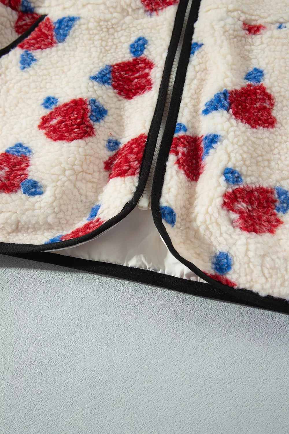 Cream with red flowers floral zip-up fleece jacket, hem and zipper detail.