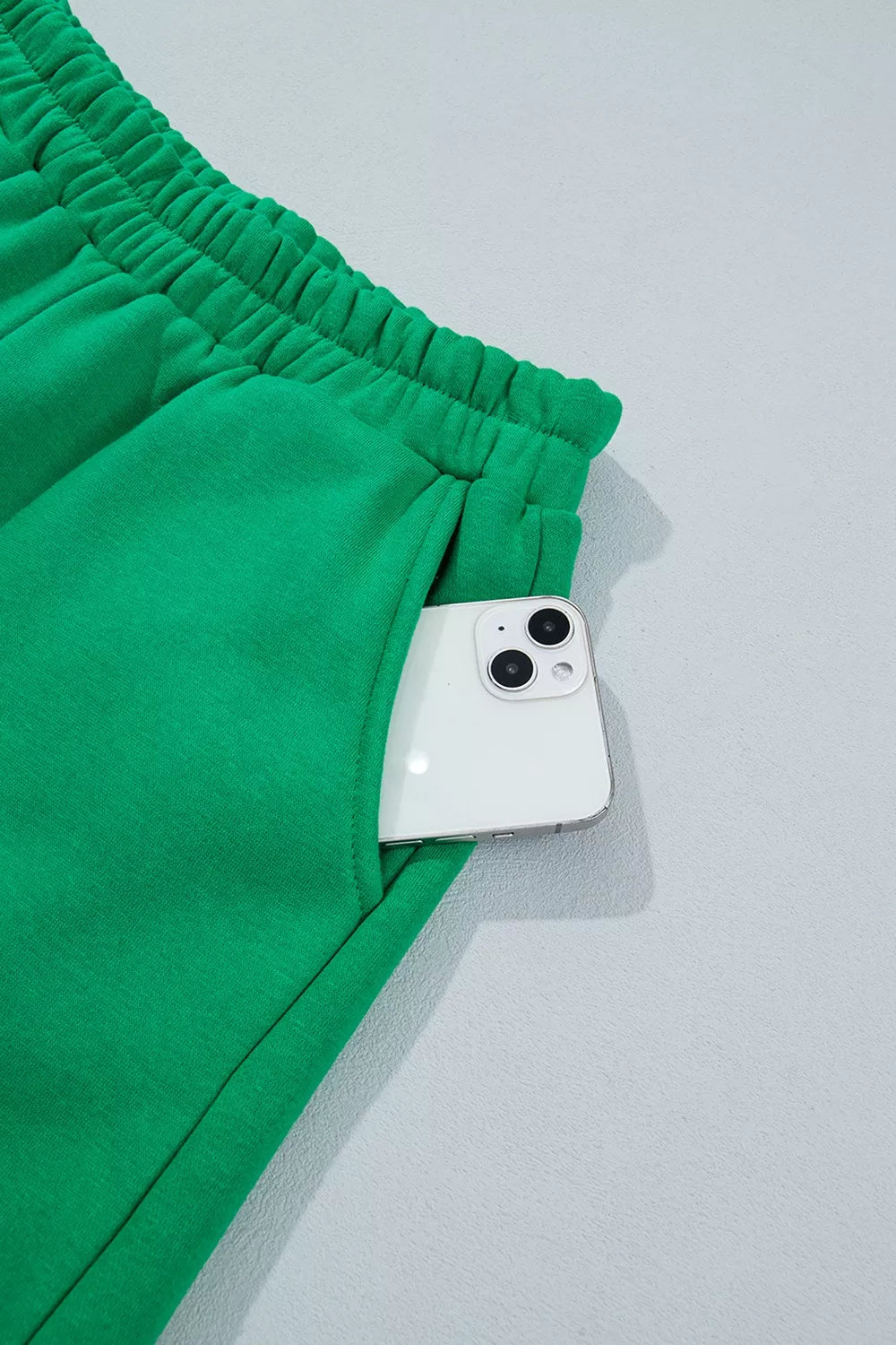 Green sweatshirt and shorts set with polka-dot trim, shorts pocket detail