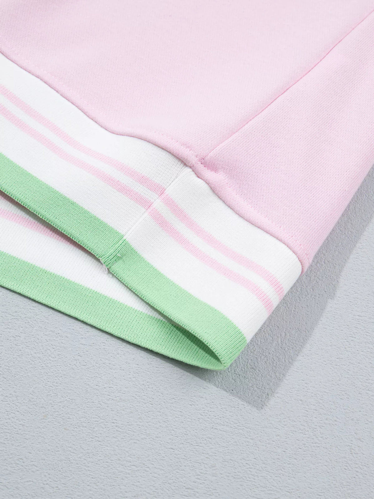 Pink sweatshirt with contrast striped ribbed trim, hem detail