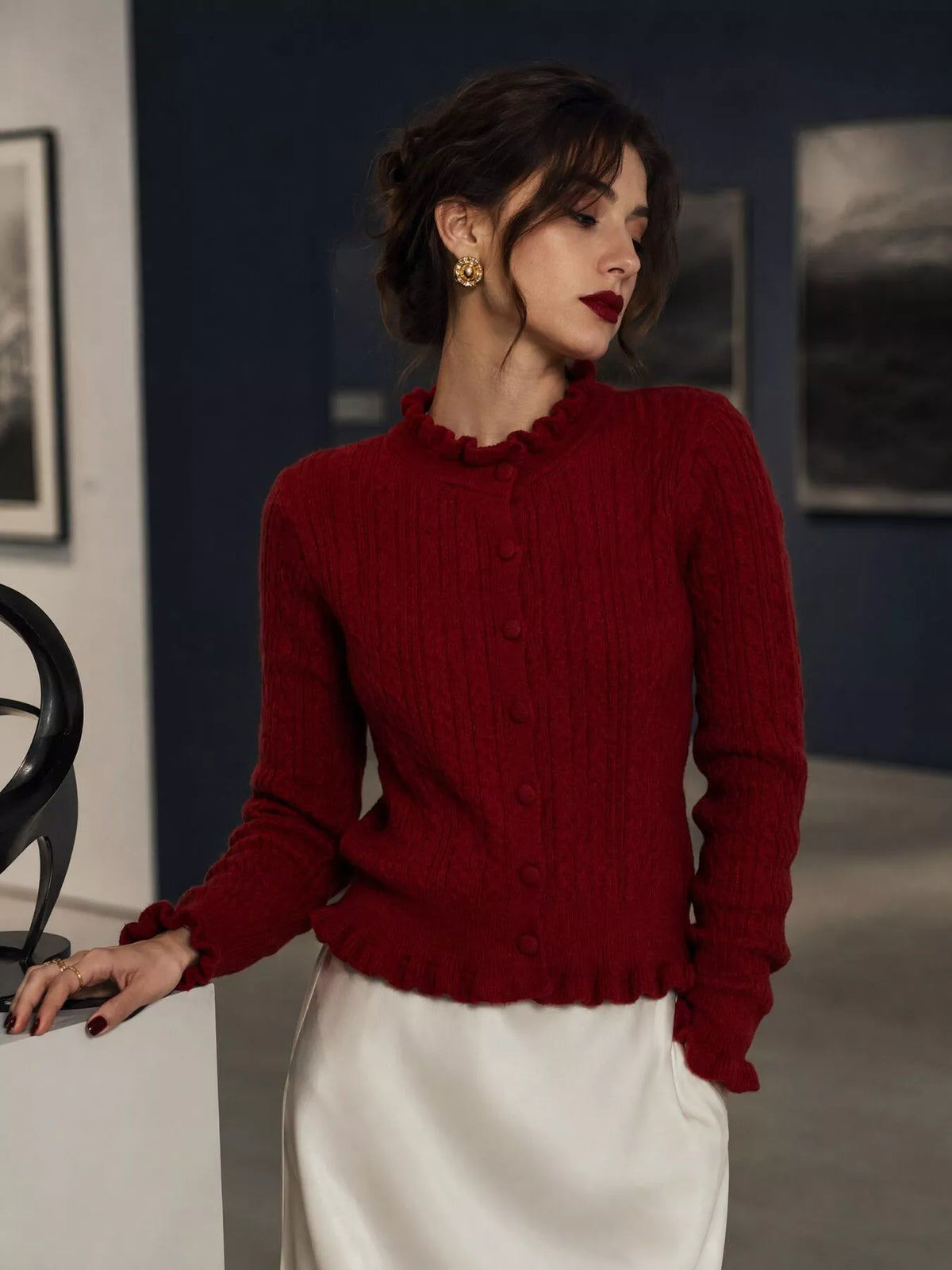 Burgundy cable-knit ruffle-trim cardigan, angled front view.