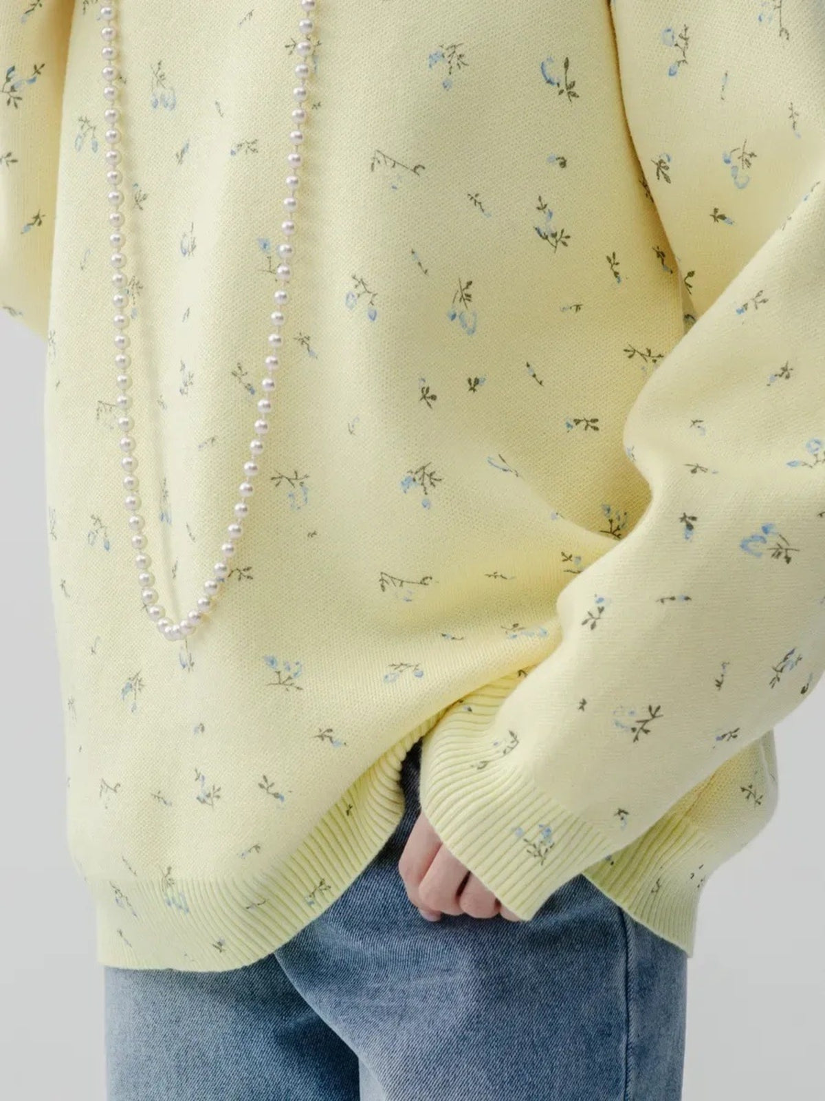 Yellow floral dropped-shoulder oversized sweater, sleeve and hem detail.
